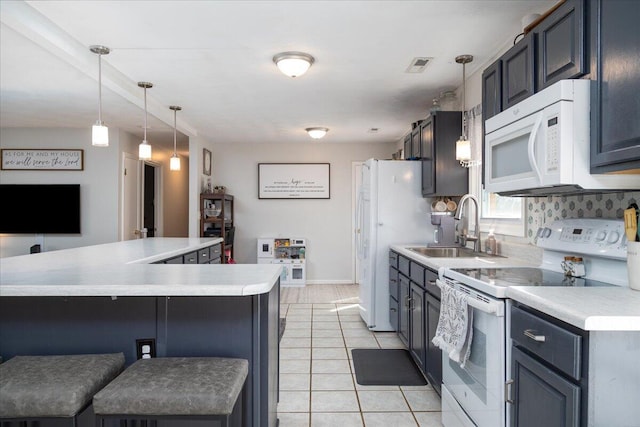 kitchen featuring a breakfast bar, sink, light tile patterned floors, pendant lighting, and white appliances