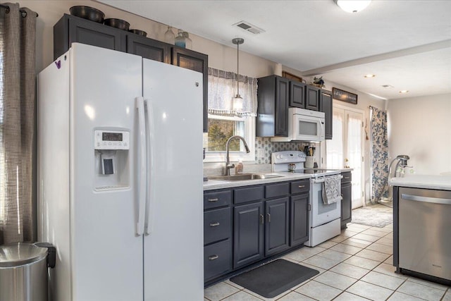 kitchen featuring sink, white appliances, a wealth of natural light, and decorative light fixtures