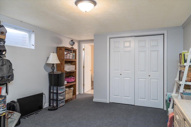 bedroom with a closet, dark carpet, and a textured ceiling