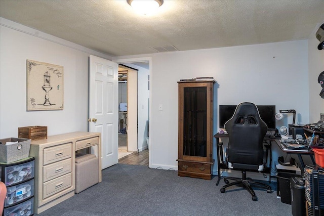 carpeted home office featuring a textured ceiling