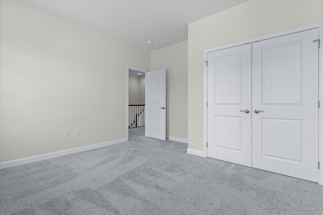 unfurnished bedroom featuring light carpet and a closet