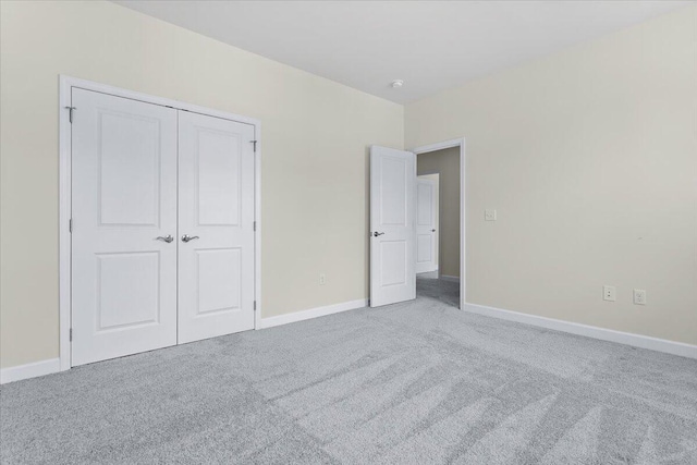 unfurnished bedroom featuring a closet and light carpet