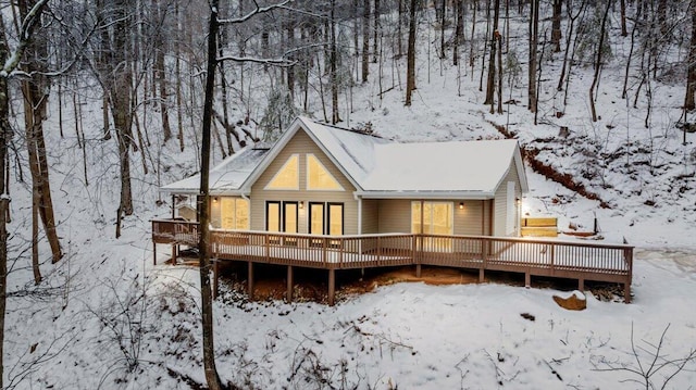 snow covered house with a wooden deck