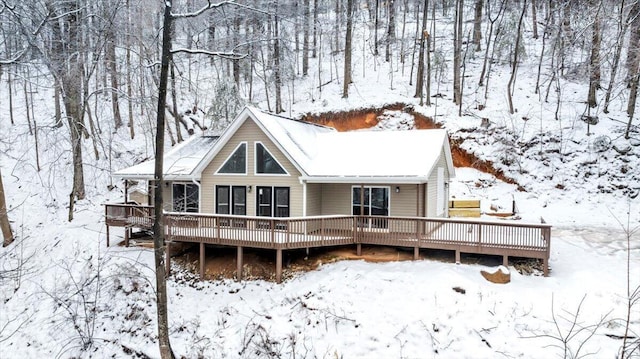 snow covered property with a wooden deck