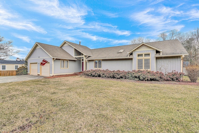 view of front of home with a garage, a front lawn, and driveway