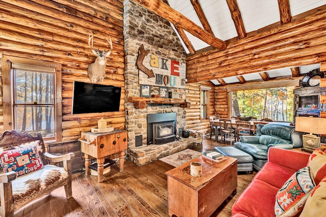 living room with beam ceiling, hardwood / wood-style flooring, a wood stove, and high vaulted ceiling