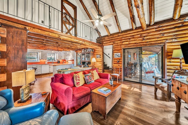 living room featuring hardwood / wood-style floors, high vaulted ceiling, beamed ceiling, and ceiling fan