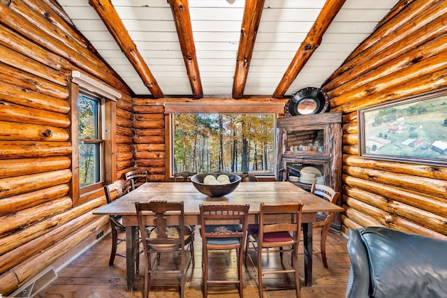 unfurnished dining area featuring lofted ceiling with beams and dark hardwood / wood-style floors