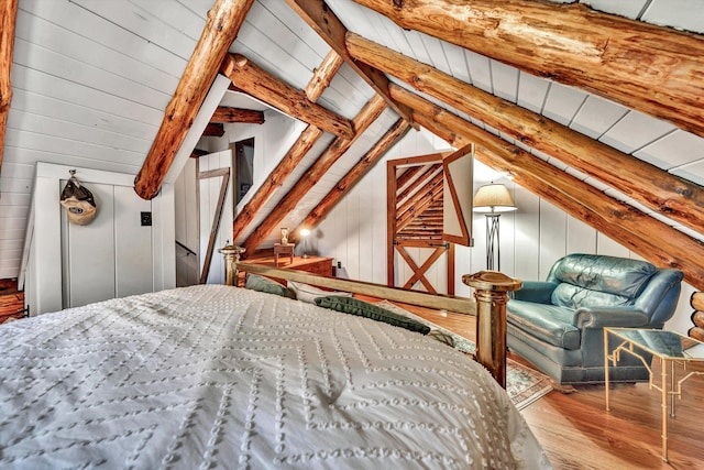 bedroom featuring wooden walls, hardwood / wood-style floors, and vaulted ceiling with beams