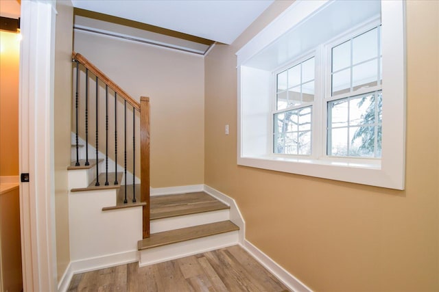 staircase with wood finished floors and baseboards