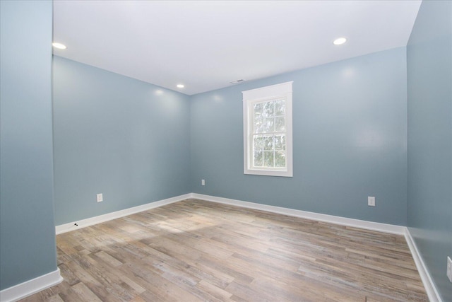 spare room featuring recessed lighting, light wood-style flooring, and baseboards