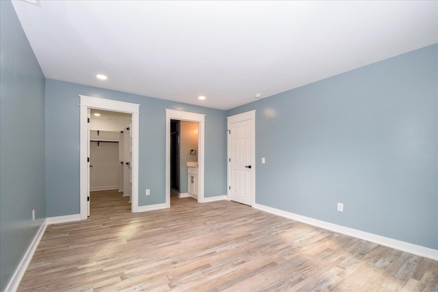 unfurnished bedroom with light wood-style floors, a closet, and recessed lighting