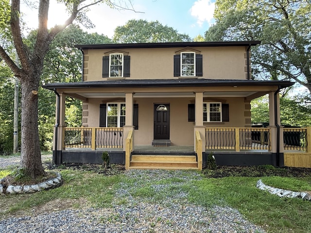 farmhouse-style home featuring covered porch and stucco siding