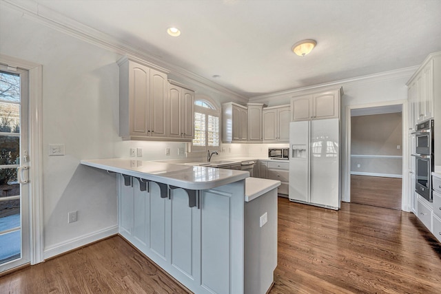 kitchen with dark wood-type flooring, white cabinetry, black microwave, white refrigerator with ice dispenser, and kitchen peninsula