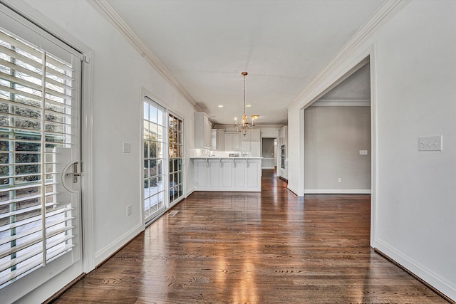 unfurnished dining area with dark hardwood / wood-style flooring, crown molding, and a chandelier