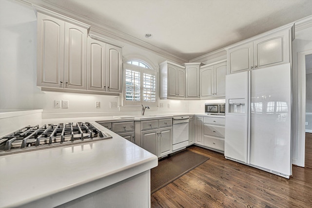 kitchen with dark hardwood / wood-style flooring, sink, white appliances, and white cabinets