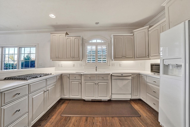 kitchen featuring appliances with stainless steel finishes, sink, white cabinets, dark hardwood / wood-style flooring, and crown molding