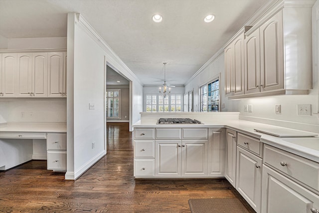 kitchen with stainless steel gas stovetop, white cabinetry, dark hardwood / wood-style flooring, and decorative light fixtures