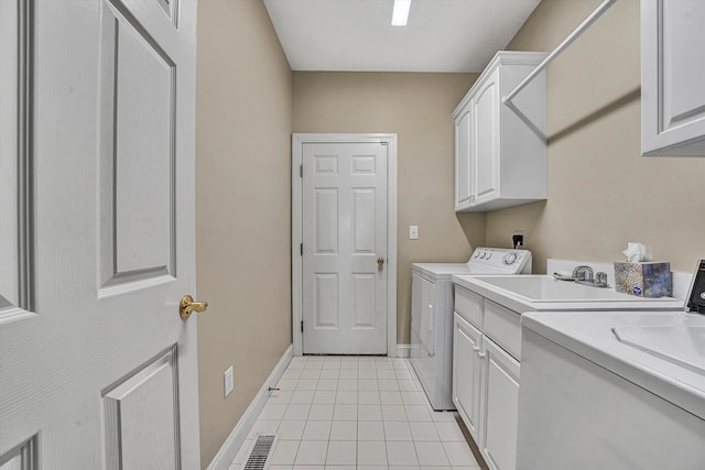 clothes washing area with cabinets, sink, washer and dryer, and light tile patterned floors