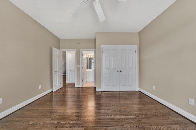 unfurnished bedroom with connected bathroom, dark wood-type flooring, a closet, and ceiling fan