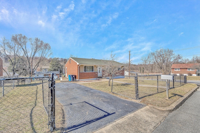 view of front facade featuring fence, a gate, a front lawn, and brick siding