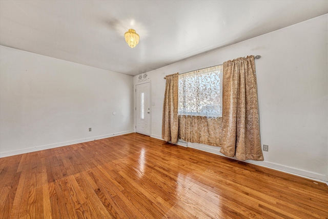 unfurnished room featuring baseboards and wood finished floors