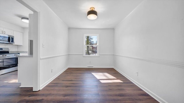 unfurnished room with dark wood-type flooring, visible vents, ornamental molding, and baseboards