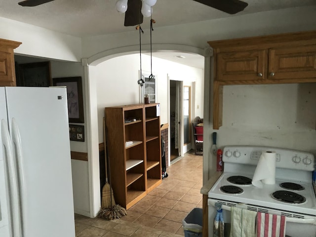 kitchen with arched walkways, ceiling fan, light tile patterned floors, white appliances, and pendant lighting