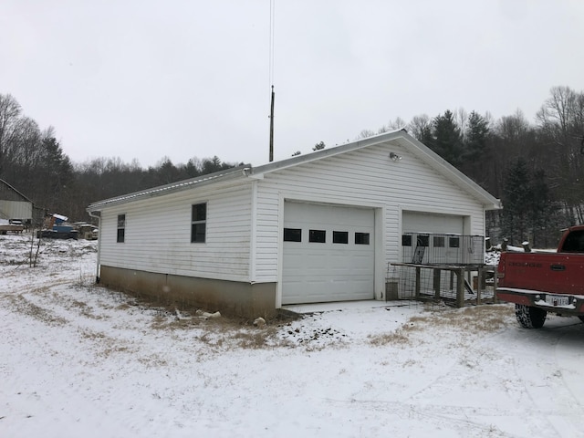 snow covered garage featuring a detached garage