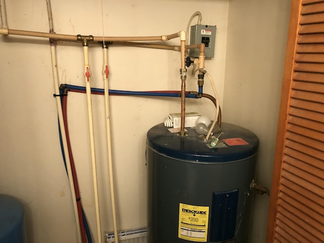 utility room with a baseboard heating unit and water heater