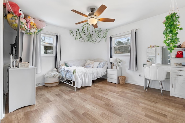 bedroom with baseboards, multiple windows, light wood-style flooring, and a ceiling fan