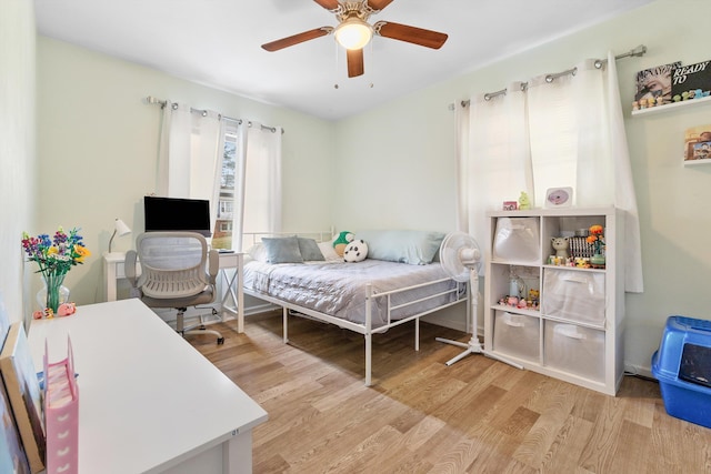 bedroom with a ceiling fan and light wood-style flooring