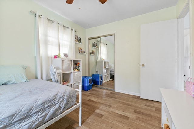 bedroom with light wood finished floors, a ceiling fan, and a closet