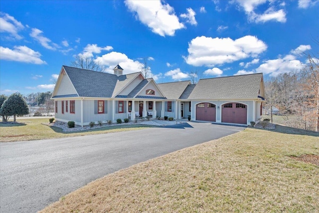 view of front of home with a garage, aphalt driveway, and a front yard