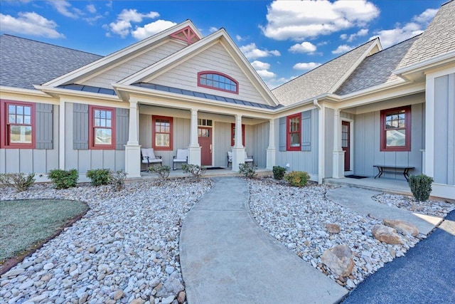 exterior space with covered porch, a shingled roof, and board and batten siding