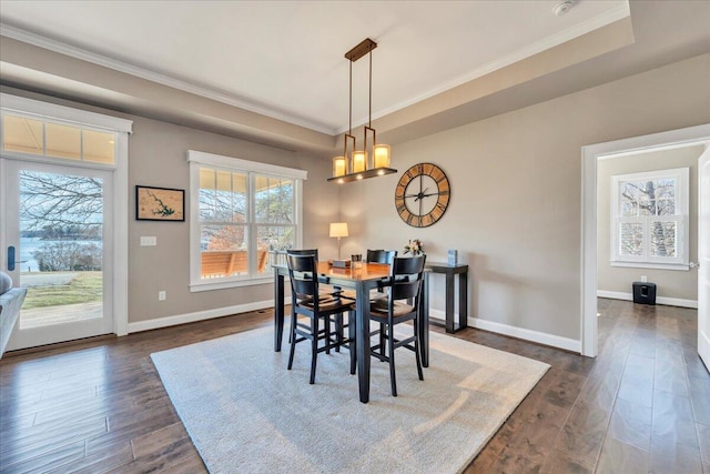 dining area featuring ornamental molding, dark wood-style flooring, and baseboards