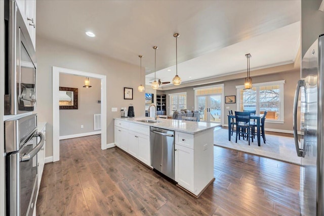 kitchen with visible vents, white cabinets, dark wood-type flooring, a peninsula, and stainless steel appliances