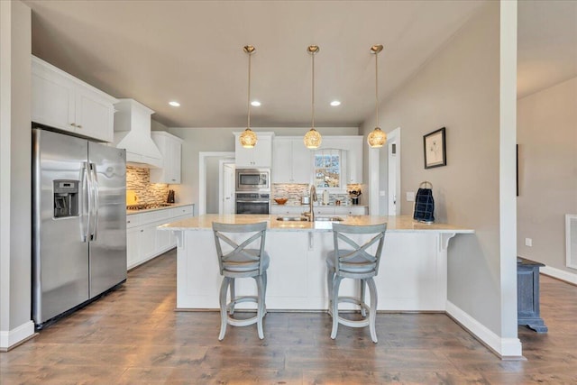 kitchen with a breakfast bar, a peninsula, stainless steel appliances, premium range hood, and white cabinetry