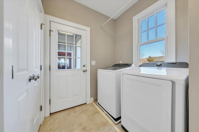 laundry room with laundry area, washer and clothes dryer, and a healthy amount of sunlight