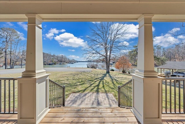 wooden terrace with a porch, a lawn, and a water view