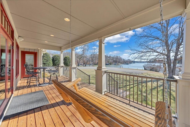 deck featuring covered porch and a water view