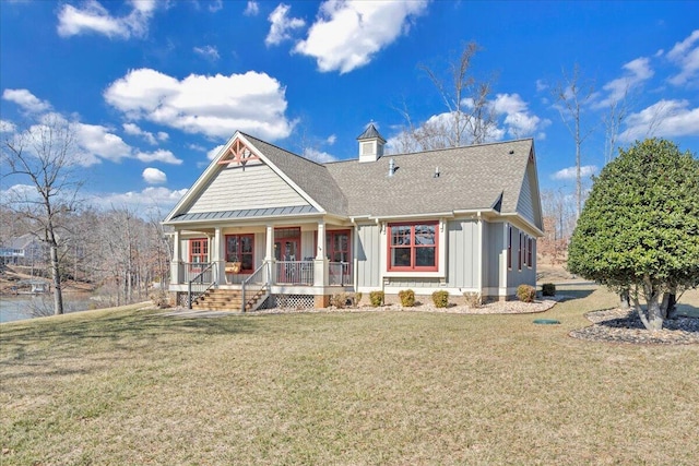 view of front of property with board and batten siding, roof with shingles, a porch, and a front lawn