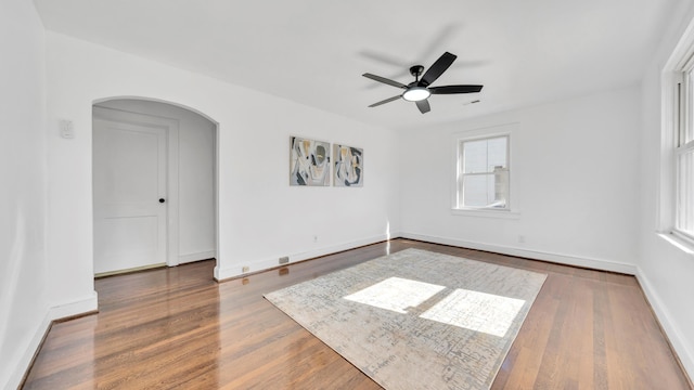 empty room featuring hardwood / wood-style flooring, a healthy amount of sunlight, and ceiling fan