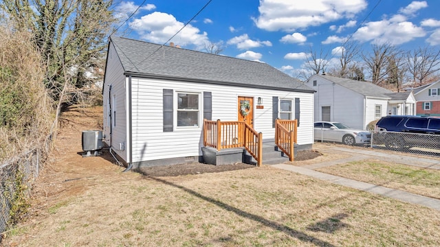 bungalow-style home with central AC and a front lawn