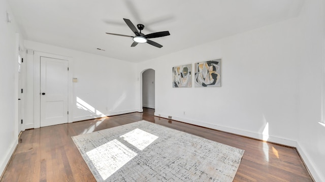 empty room featuring dark hardwood / wood-style flooring and ceiling fan