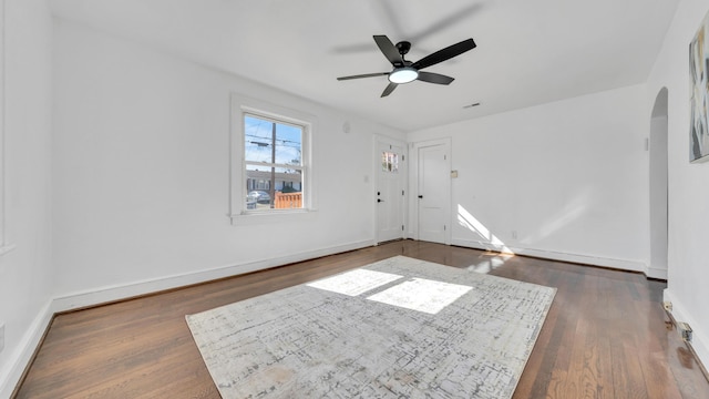 empty room featuring dark wood-type flooring and ceiling fan