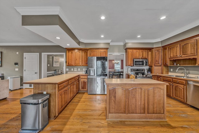 kitchen featuring a kitchen island, a sink, stainless steel appliances, and brown cabinetry