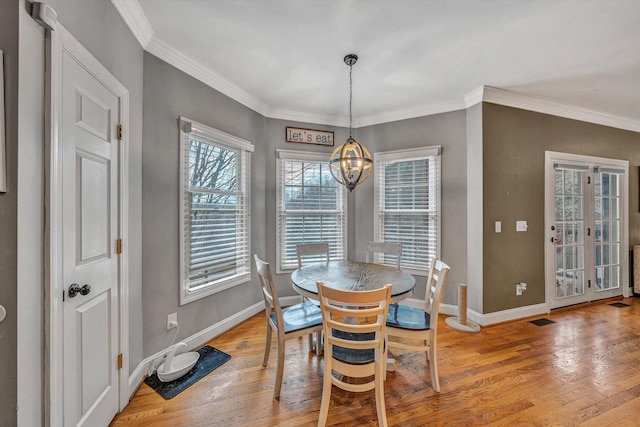 dining room featuring light wood finished floors, baseboards, a chandelier, and visible vents