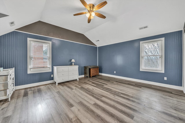 unfurnished bedroom featuring wood finished floors, multiple windows, and visible vents