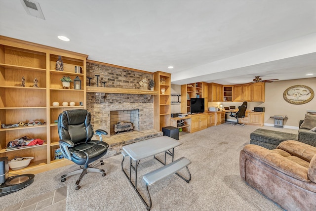living area with visible vents, baseboards, a fireplace, ceiling fan, and light carpet